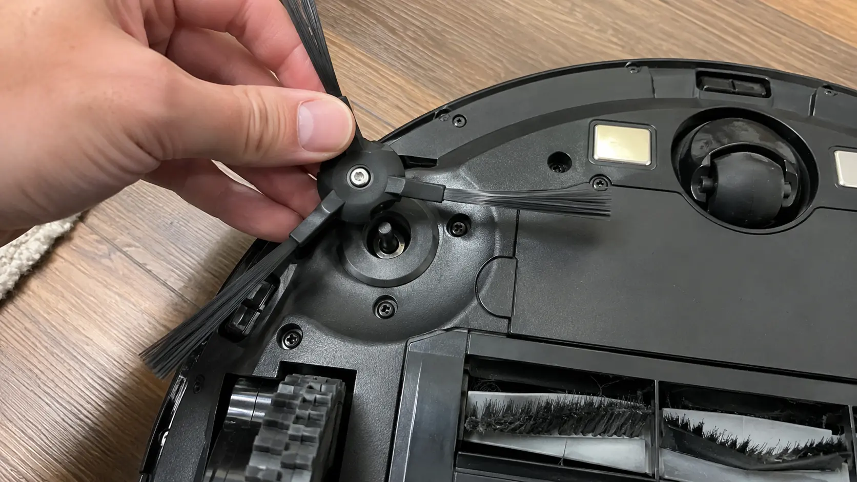 Attaching the side brush to a robot vacuum before first use.